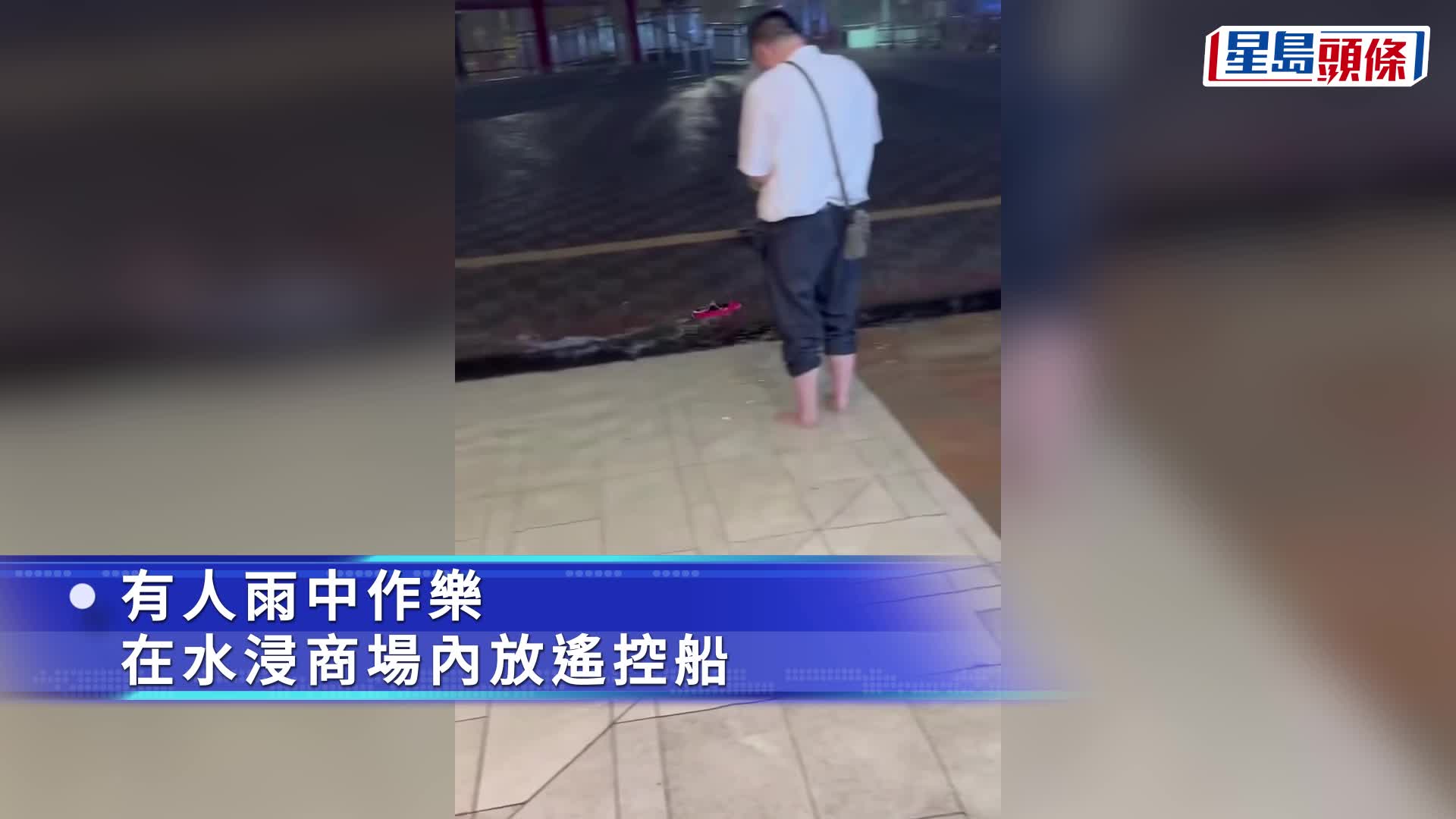 有人在黑雨中於水浸的商場內玩遙控船。